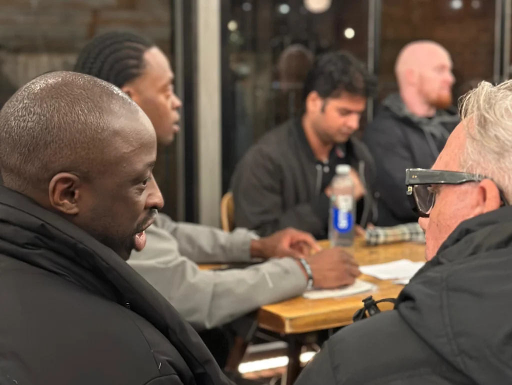 Men-engage-in-a-deep-discussion-around-a-table-during-an-MPC-event-Season-2-Session-1-Mental-Health