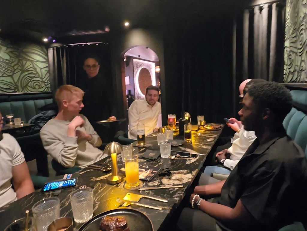 MPC-health-and-fitness-event-group-of-people-sitting-together-at-a-table-in-a-dimly-lit-restaurant