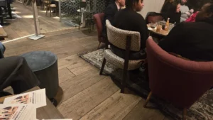 Walk-and-Talk-event-in-progress-with-MENS-PROS-PERITY-CLUB-flyers-on-table-in-cozy-cafe-setting-with-people-chatting-around-the-table