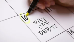 Calendar-with-Pay-off-debt-written-on-it-Planning-debt-payoff-with-a-focused-money-mindset-for-men-in-their-20s