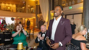 Ronaldo-Hare-stands-and-smiles-as-he-is-applauded-by-attendees-at-the-2025-Ladies-First-Awards-gala-event