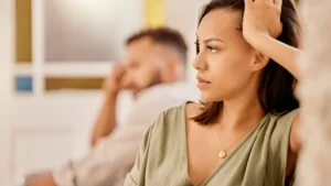 A-woman-looking-pensive-while-a-man-sits-nearby-both-showing-emotional-unavailability