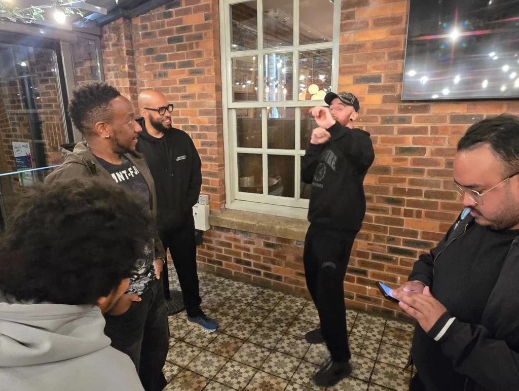 A-group-of-people-gathered-at-a-networking-event-with-one-individual-using-a-phone-and-others-in-conversation