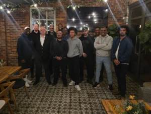 A-group-photo-of-attendees-at-a-networking-event-all-smiling-and-posing-together-in-a-casual-setting