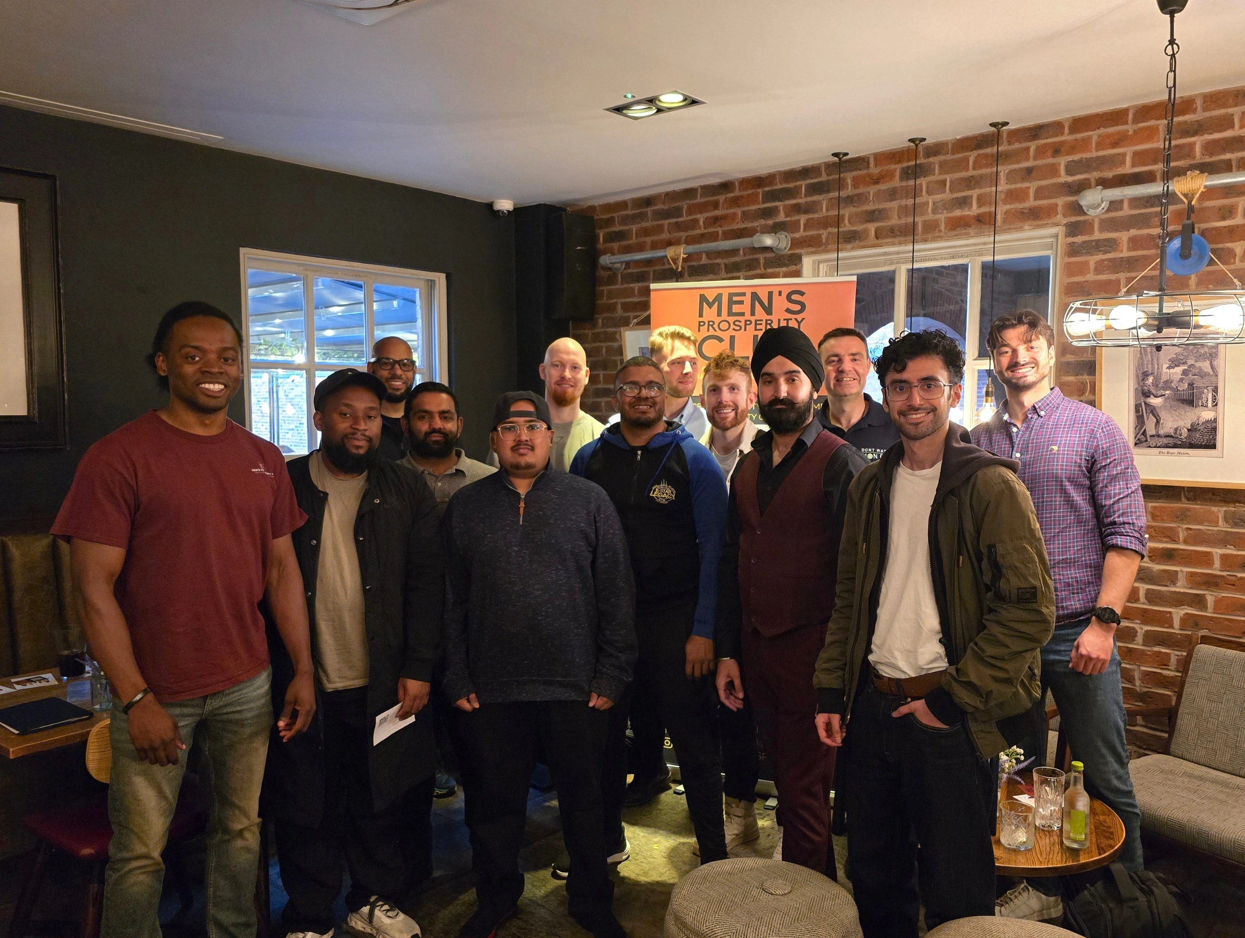 Group-of-men-posing-for-a-photo-in-front-of-the-Men's-Prosperity-Club-banner