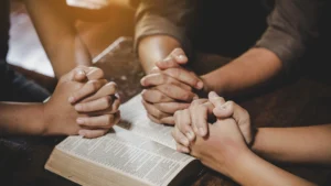 Hands-in-prayer-over-an-open-Bible-reflecting-Faith-and-Mental-Health