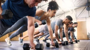 People-focused-on-mindful-fitness-while-performing-dumbbell-exercises-in-a-workout-class