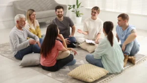A-group-of-people-sitting-on-pillows-in-a-circle-discussing-stress-and-anxiety-management-in-a-relaxed-group-setting