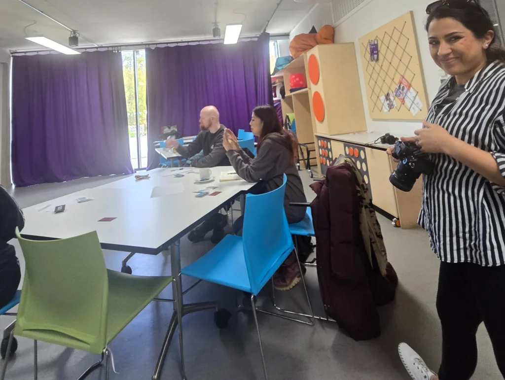 Attendees-at-the-PD-workshop-with-one-person-taking-a-photo-as-they-listen-to-the-presentation-by-John-Kenny