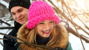 Couple-smiling-in-the-snow-enjoying-winter-romance-during-cuffing-season