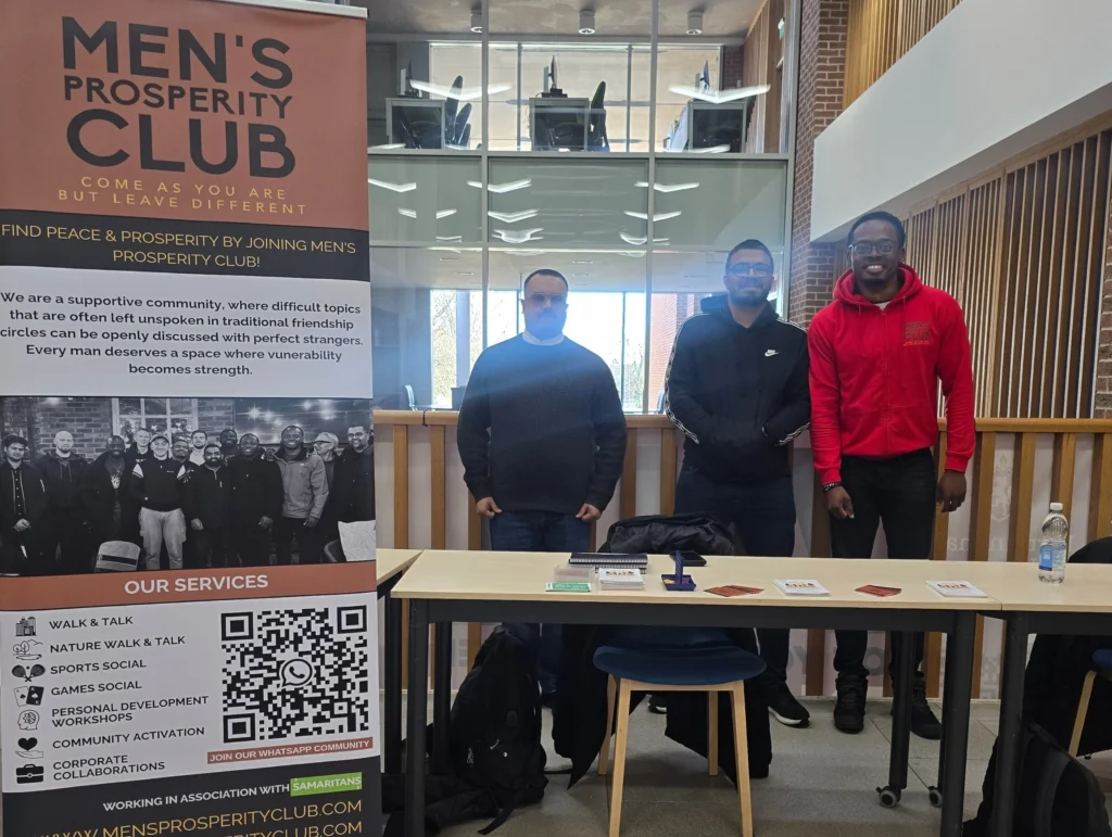Newman-University-Event-Men's-Prosperity-Club-booth-with-three-participants-standing-together