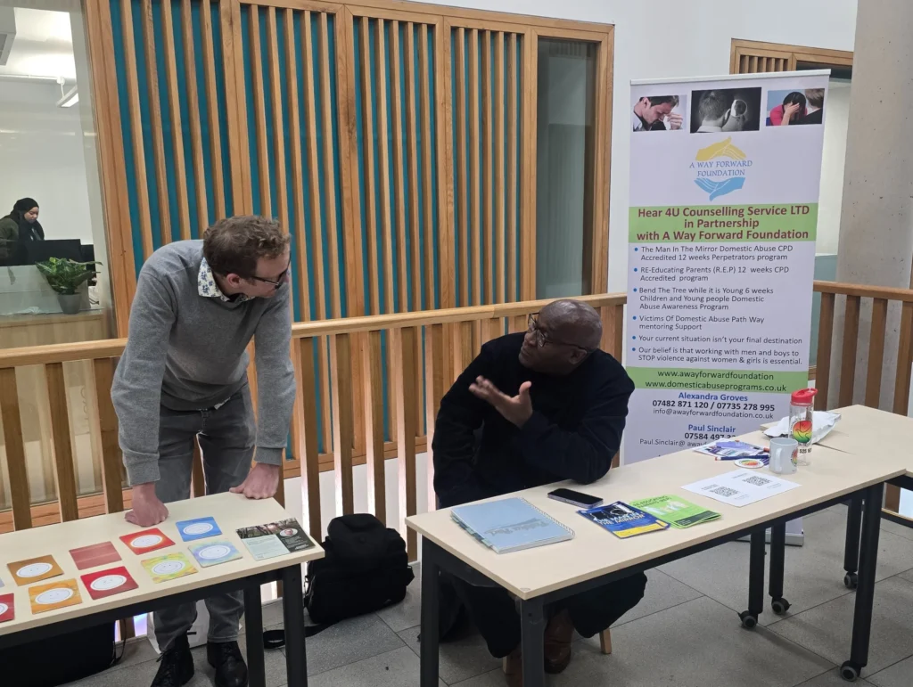 Newman-University-Event-Men's-Prosperity-Club-booth-with-two-participants-in-a-discussion