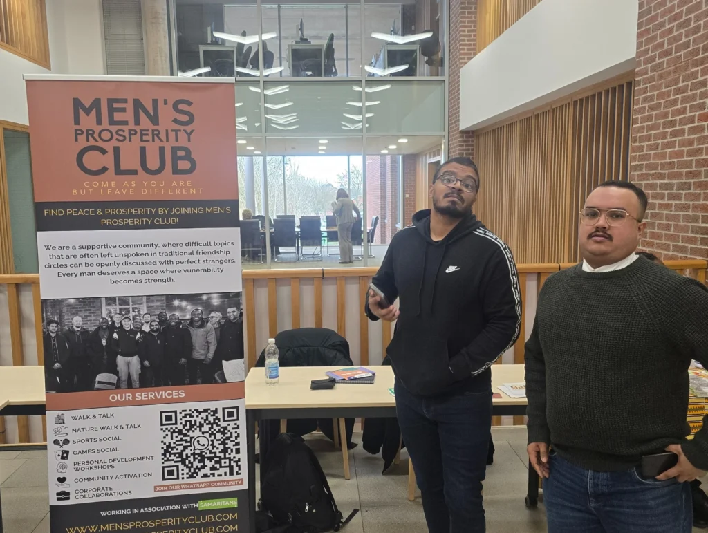 Newman-University-Event-Participant-from-Men's-Prosperity-Club-talking-with-a-visitor-at-the-booth