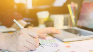 Close-up-of-a-hand-writing-on-a-notebook-with-financial-data-for-Strategic-Financial-Planning