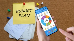 Hand-holding-phone-with-budget-pie-chart-next-to-notes-and-receipts-Budget-Planner