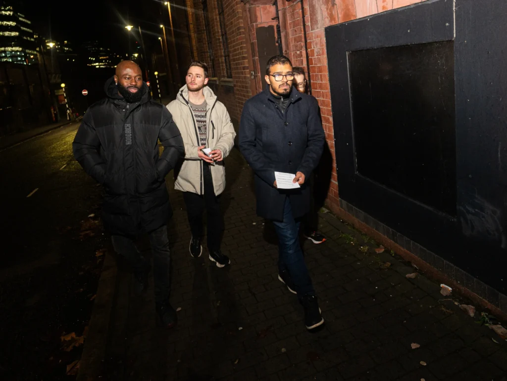 Group-walking-at-night-on-city-street-talking-about-relations-topics