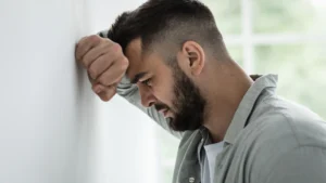 A-man-with-his-hand-on-the-wall-showing-emotional-distress-emphasizing-the-need-for-emotional-expression